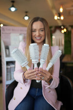 The Belle Blowdry 43mm brush styled on a salon counter with a mirror and tools