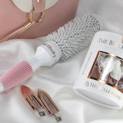 Flatlay image of The Belle Blowdry medium brush with clips and styling tools