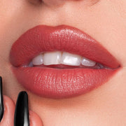 Woman applying Bliss lipstick with smooth satin finish