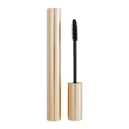 Mascara with gold casing and black brush on a white background