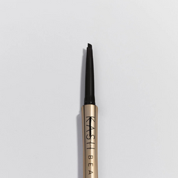 Eyebrow pencil with gold and black design on a light gray background