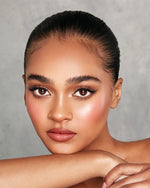 Model holding KASH Golden Hour highlighter compact