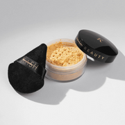 Open container of powder with a black applicator on a light gray background