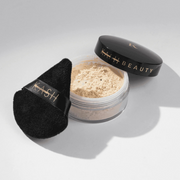 Beauty powder with black applicator on a light gray background