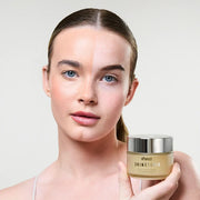 Model holding BPERFECT cleansing balm with fresh, clean face