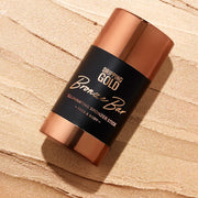 Bronzer stick with 'Dripping Gold' branding on a beige background
