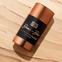 Bronzer stick with 'Dripping Gold' branding on a beige background