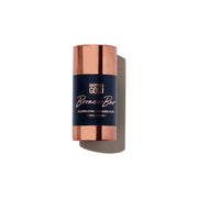 Bronze bar illuminating powder stick with rose gold cap on white background